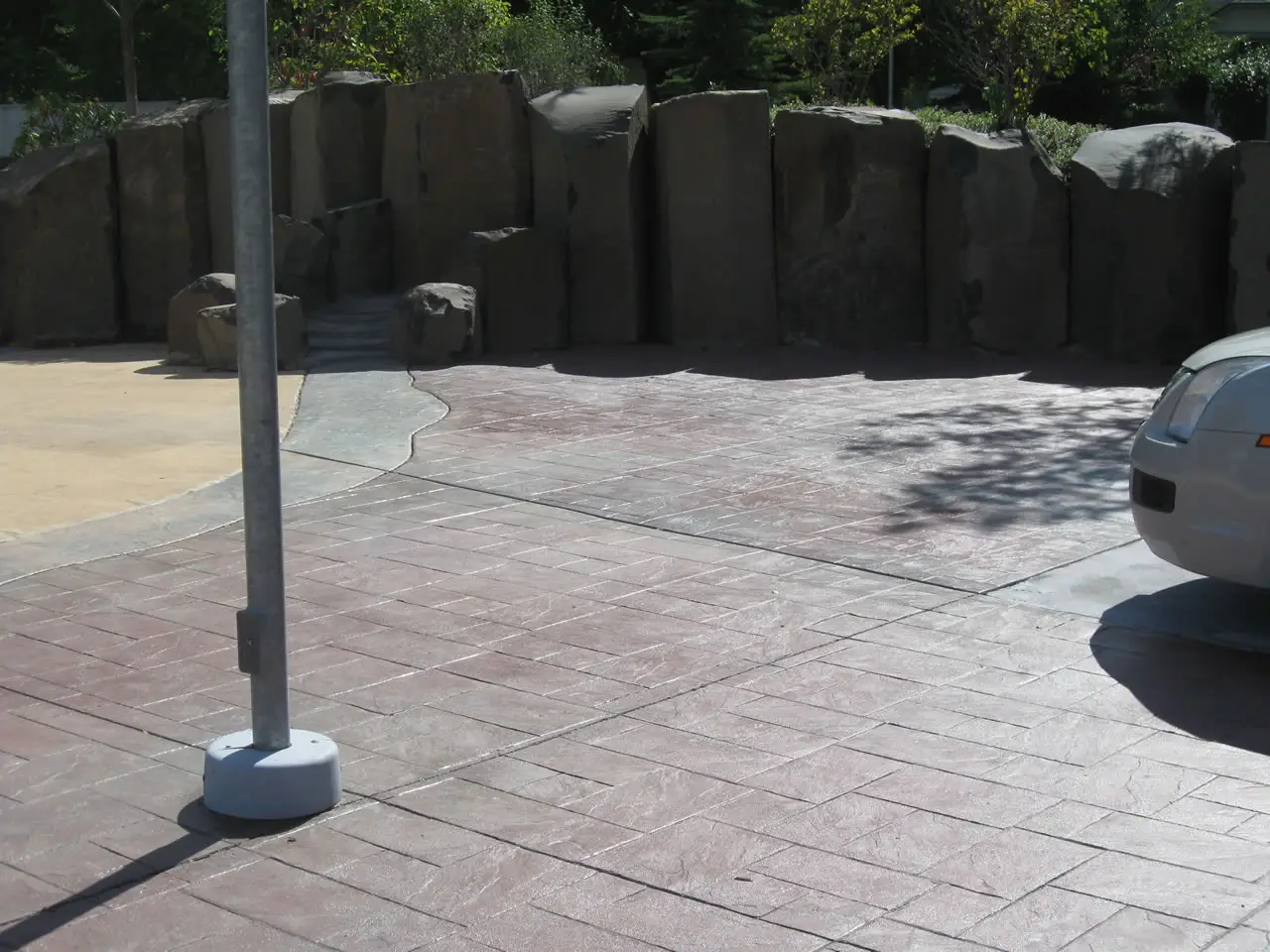 Stamped patio beside a rock retaining wall