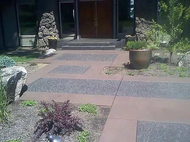 Exposed aggregate entry walk with inlaid bands and planters