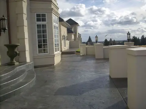 Terrace with balustrade, colored flatwork, and planters