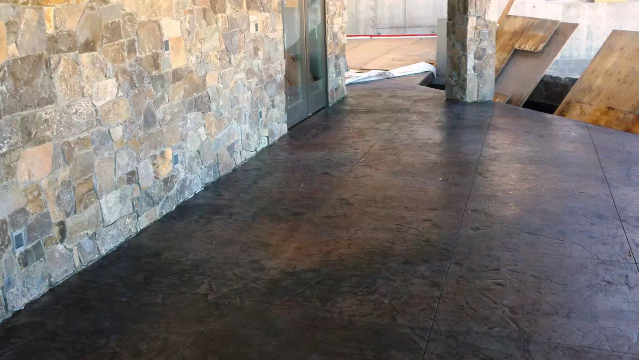 Dark stained floor beside a stacked stone wall
