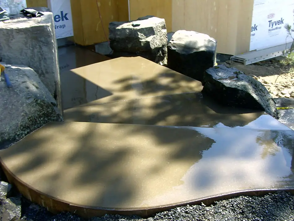 Flatwork fitted around boulders and a water feature